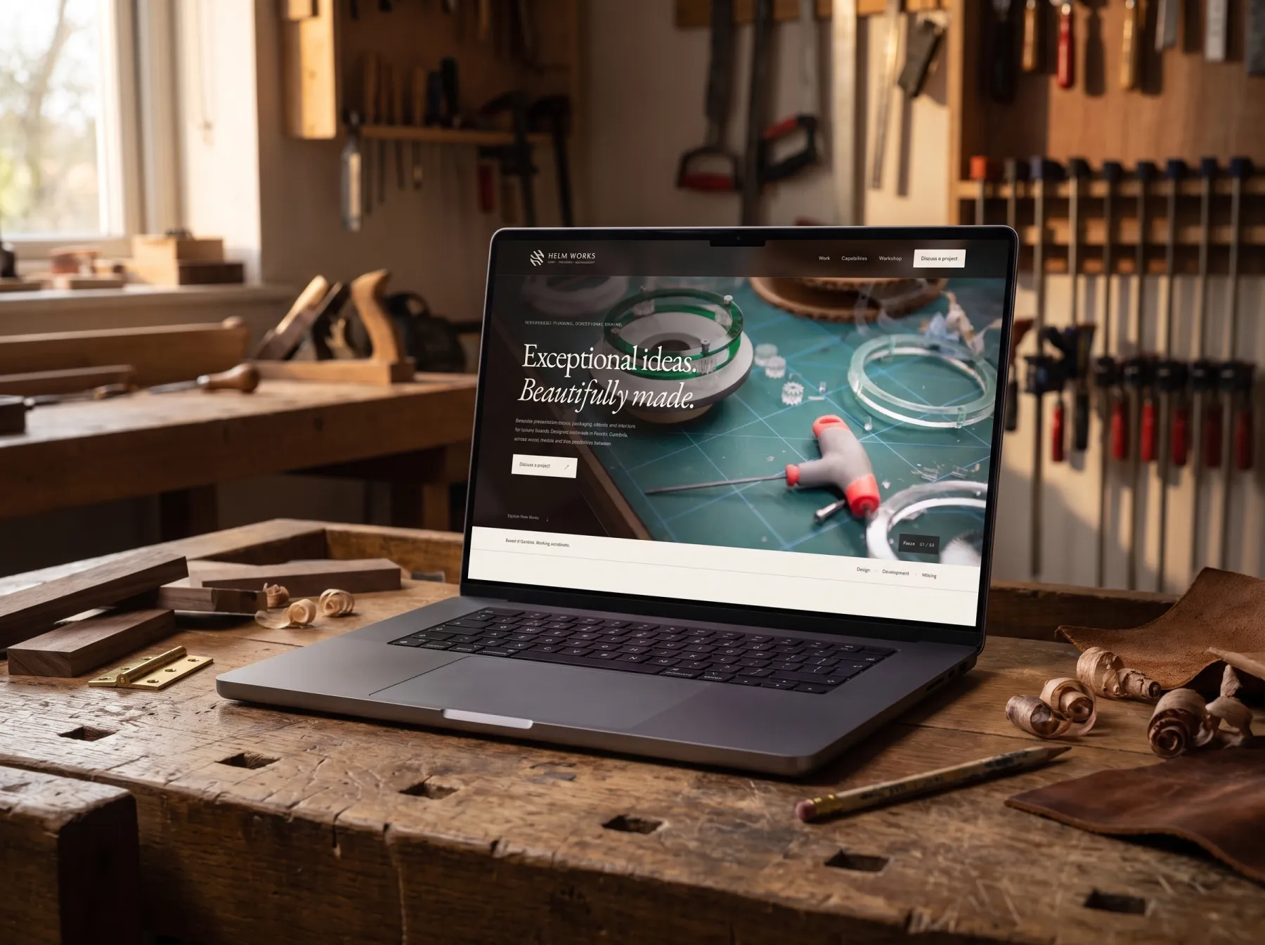 Helm Works website on a MacBook Pro on an oak workbench in a woodworking workshop
